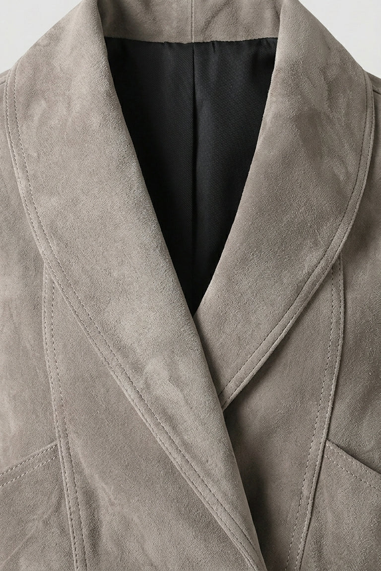 ELISE - Close-up of a gray suede coat with a plain background