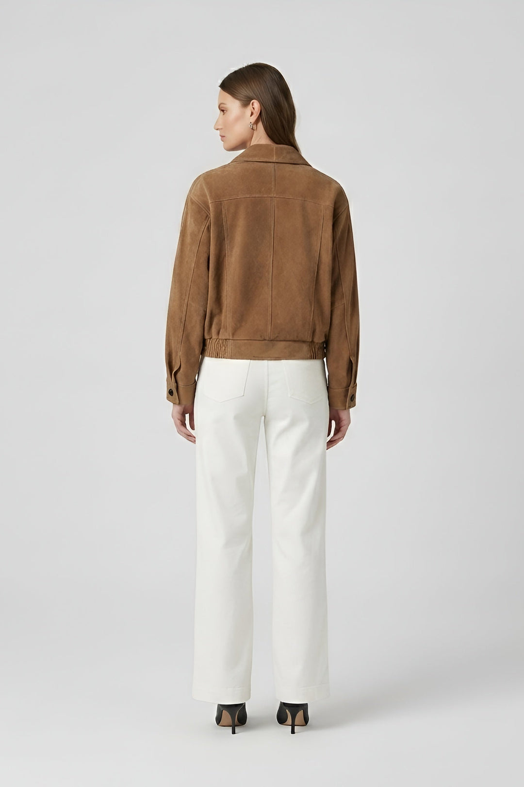 ELISE - Person wearing a brown jacket and white pants on a light gray background