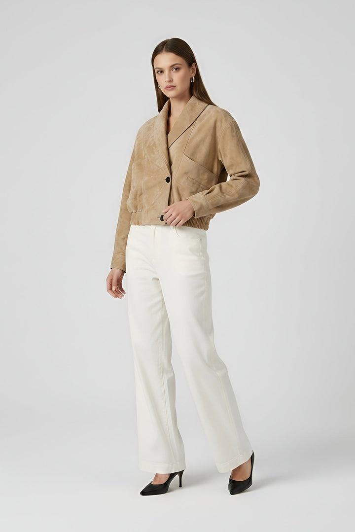 ELISE - Woman wearing a beige blazer and white pants on a plain background