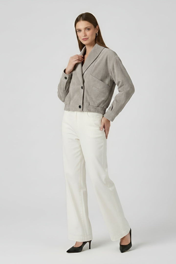 ELISE - Woman wearing a gray blazer and white pants on a white background