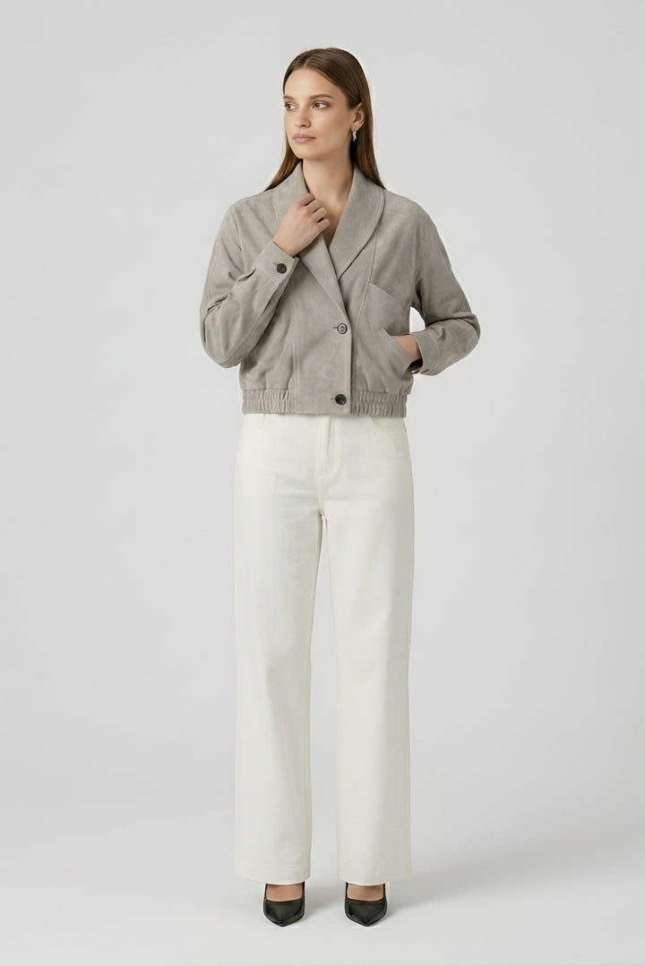 ELISE - Woman wearing a gray jacket and white pants on a white background