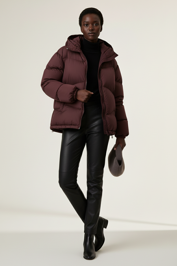 Full-body view of LYORE Lightweight Down Jacket in burgundy, styled with turtleneck and leather pants, modern winter outfit.