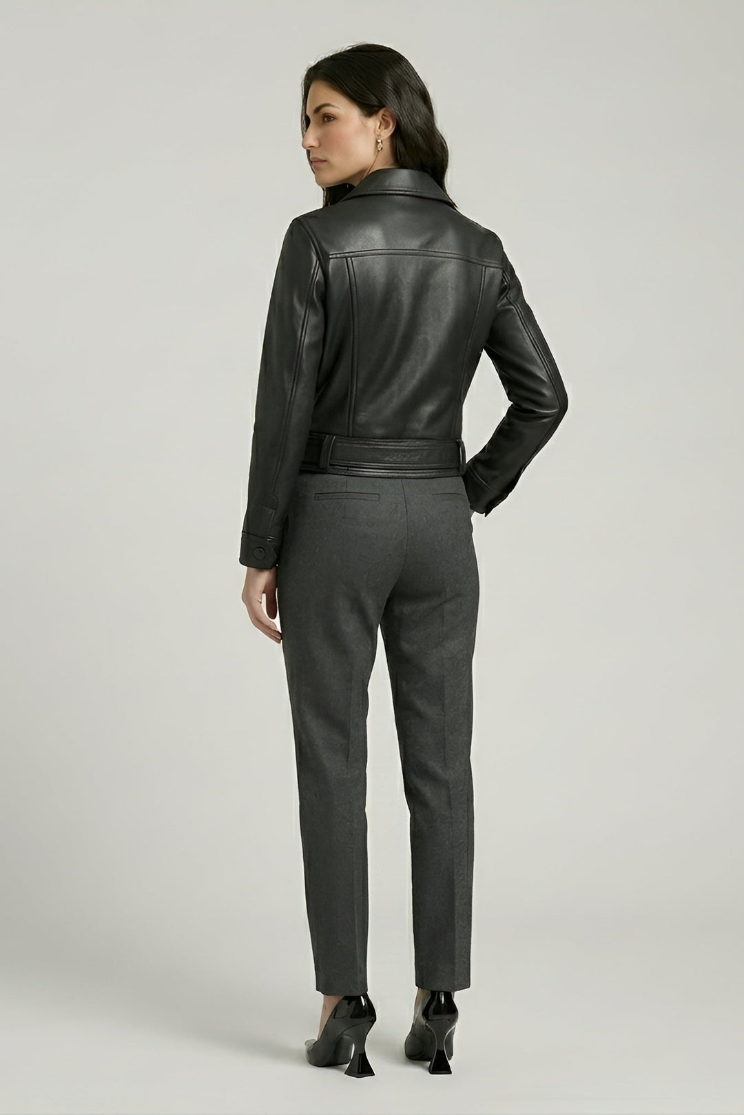 Kenzie - Back view, woman wearing black leather jacket, grey trousers