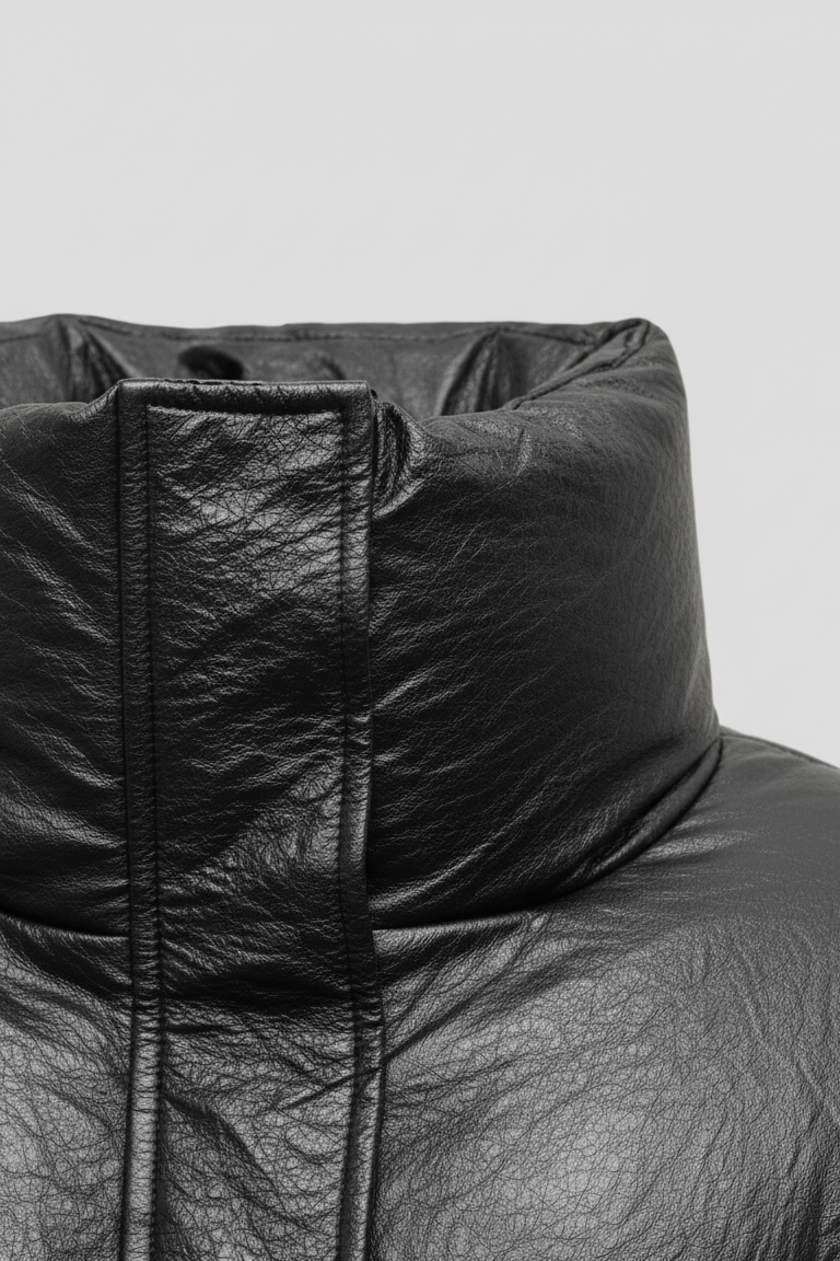 MCKENNA - Close-up of black puffer jacket collar, faux leather texture