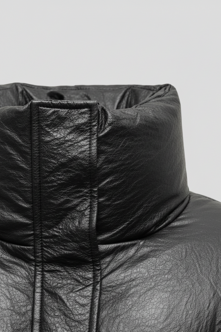 MCKENNA - Close-up of black puffer jacket collar, faux leather texture