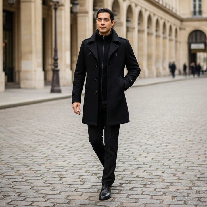 Man in a black coat walking on a cobblestone street in an urban setting