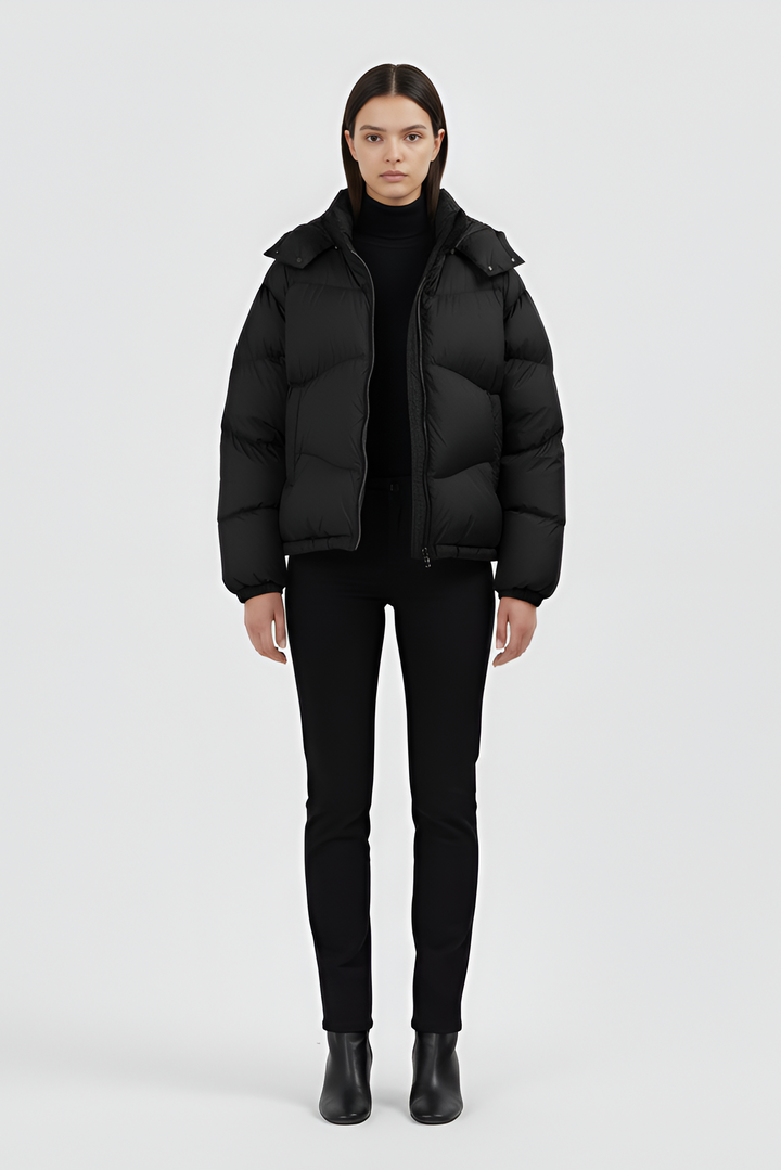 Model standing in LYORE Down Jacket, minimal studio background emphasizing sleek silhouette.