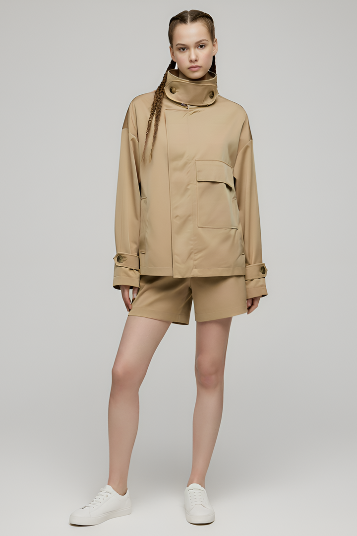 Person wearing a beige jacket and shorts set on a plain background