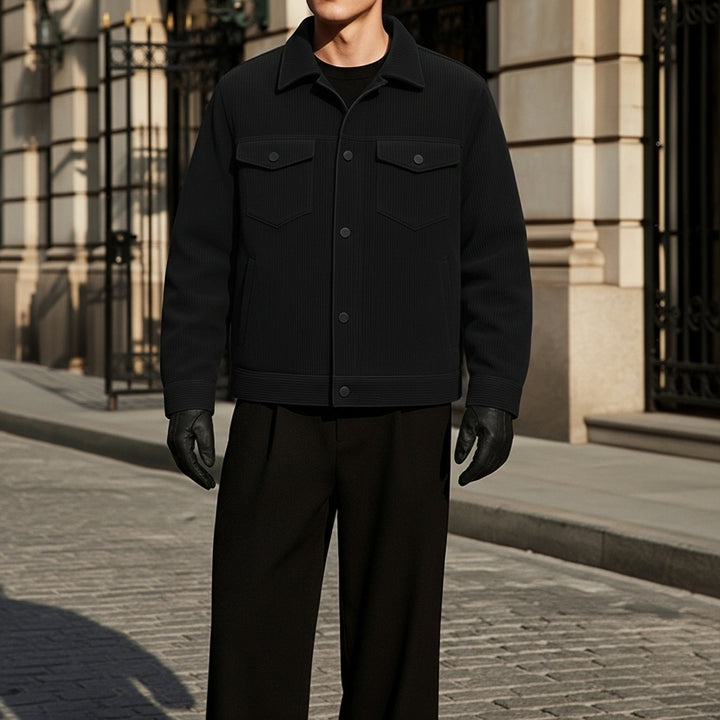 Person wearing a black jacket and gloves standing on a street.