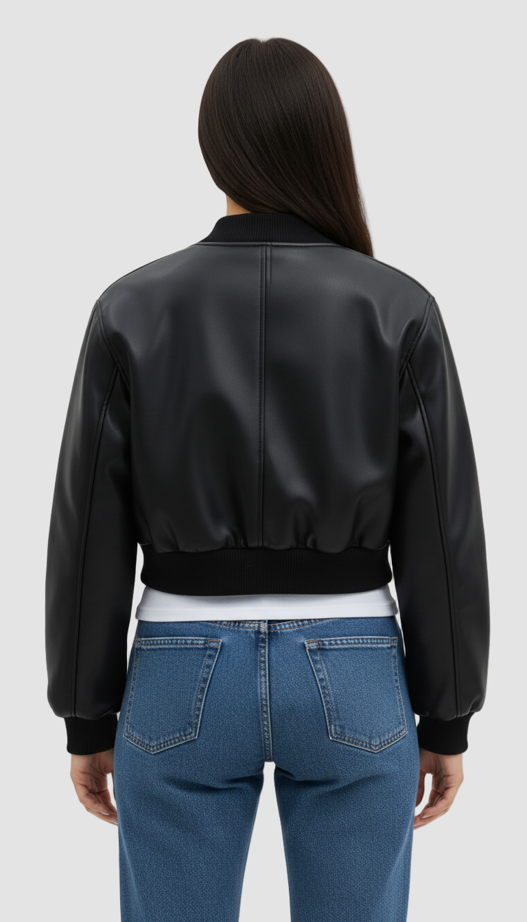 Person wearing a black leather bomber jacket and blue jeans on a white background
