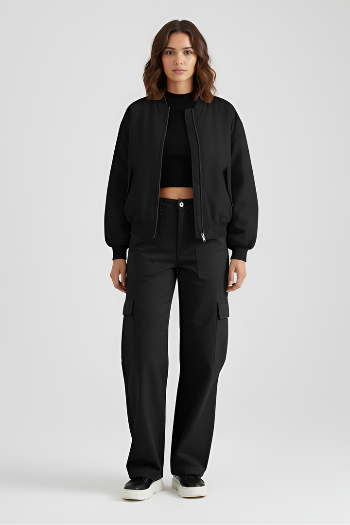 Person wearing a black outfit on a light gray background