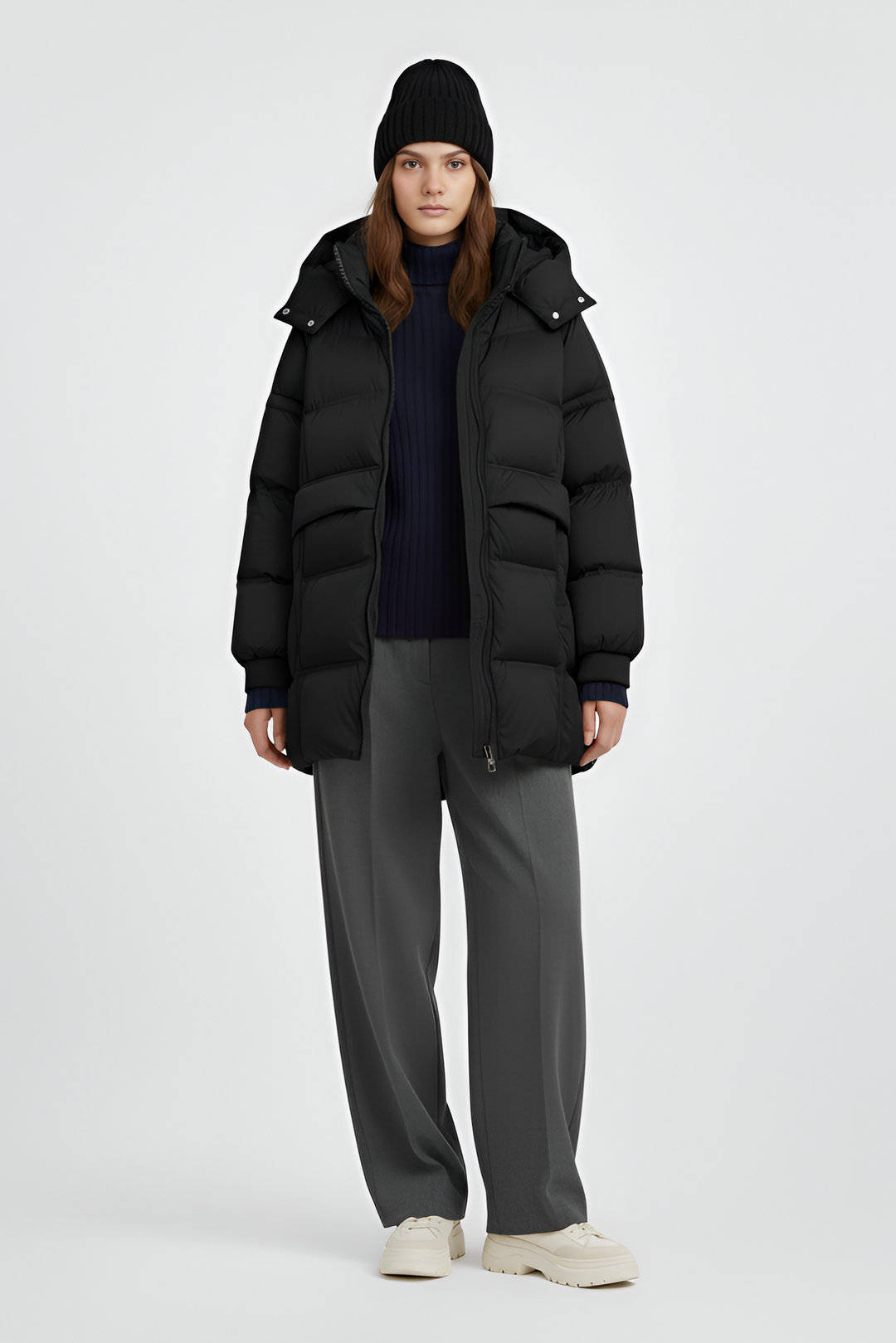 Person wearing a black puffer coat on a plain background