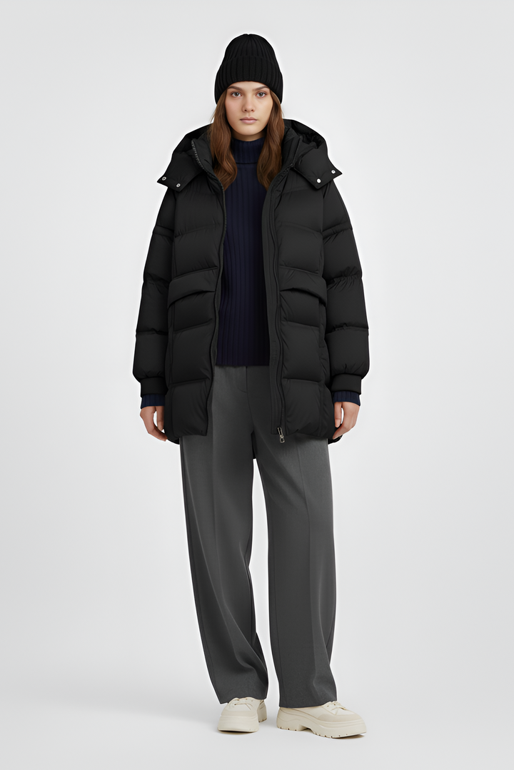 Person wearing a black puffer coat on a plain background