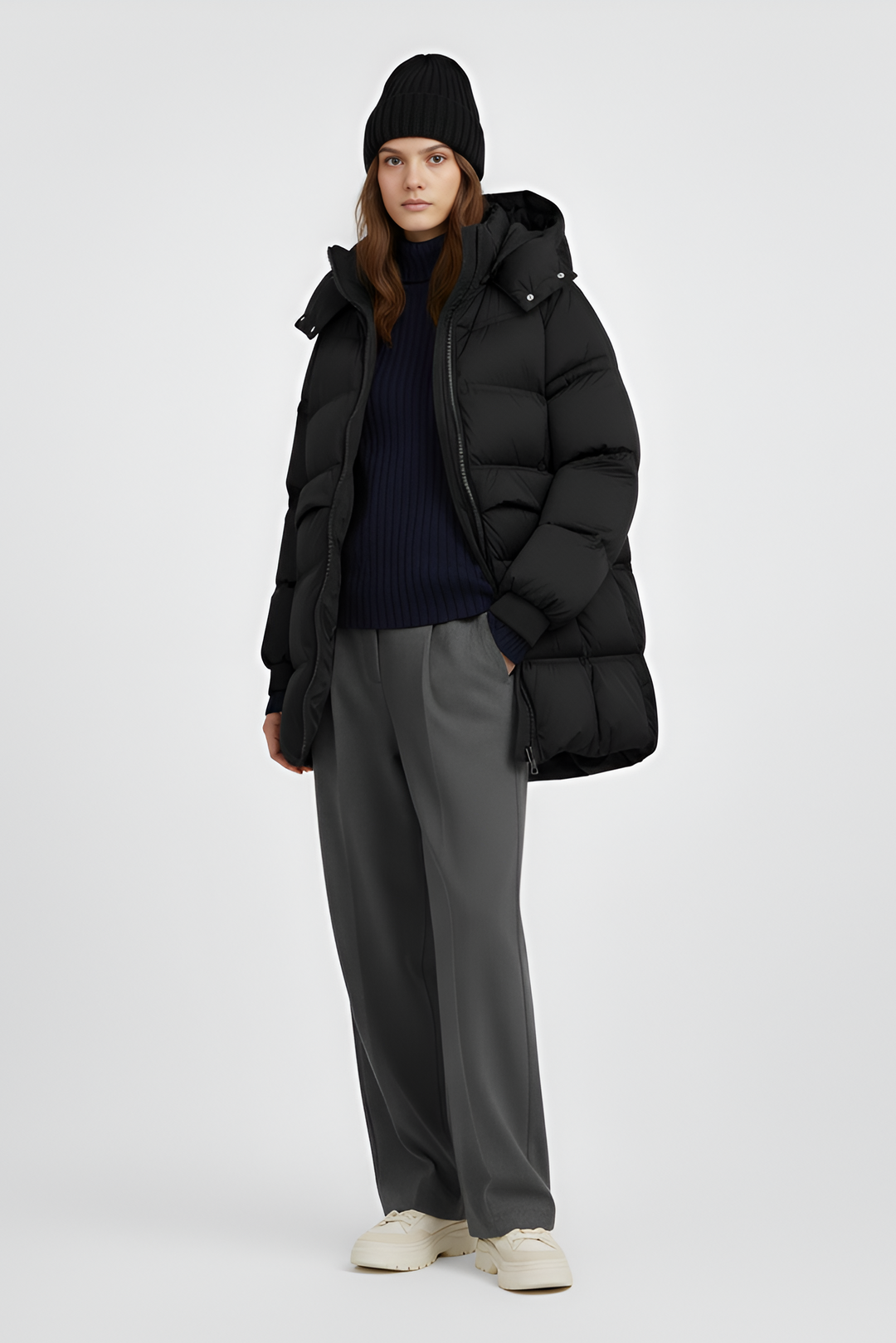 Person wearing a black puffer coat on a plain background