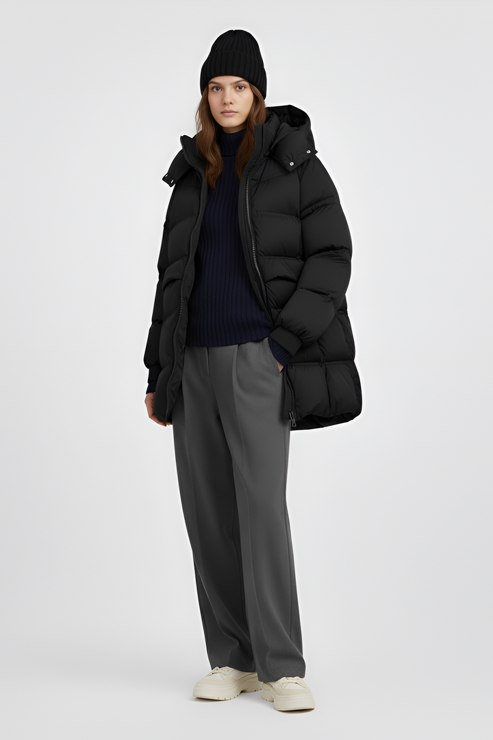 Person wearing a black puffer coat on a plain background