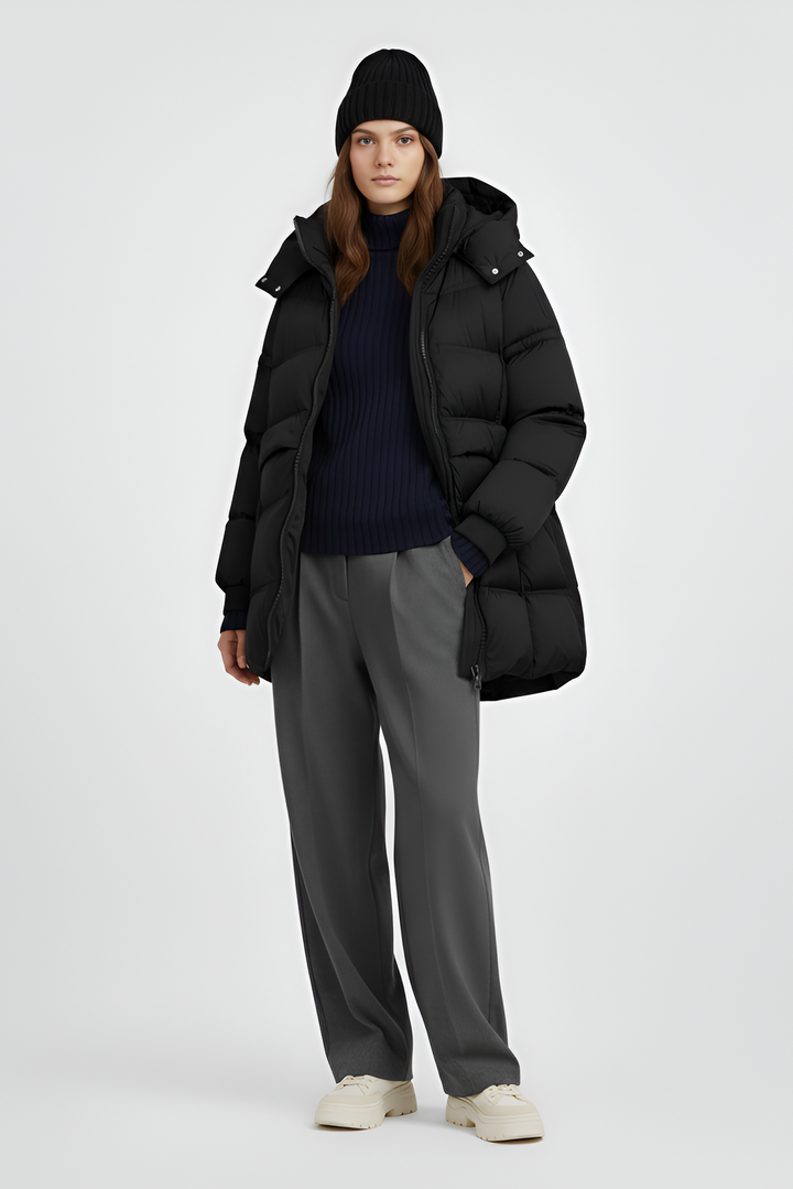 Person wearing a black puffer coat on a plain background