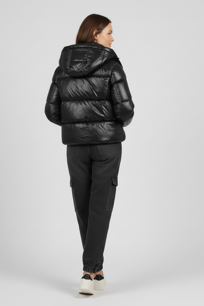 Person wearing a black puffer jacket and pants on a light gray background