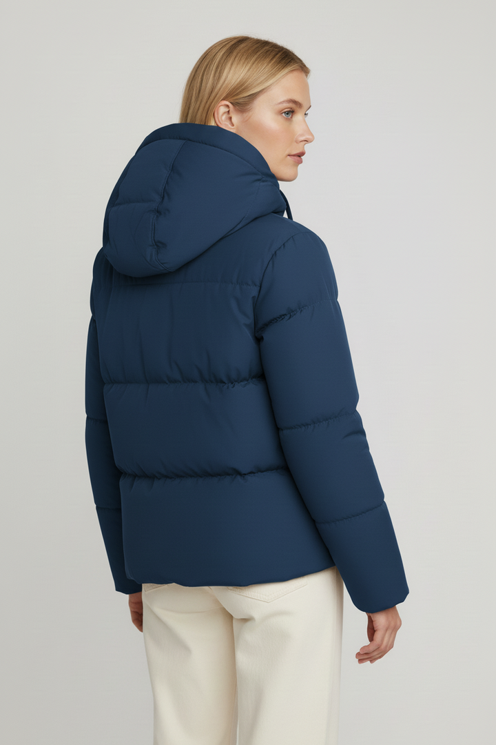 Person wearing a blue puffer jacket on a plain background