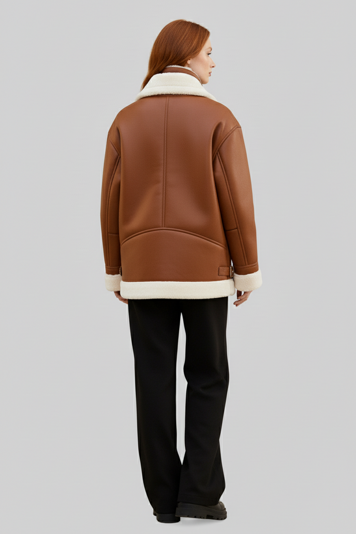 Person wearing a brown leather jacket with white fur lining on a gray background