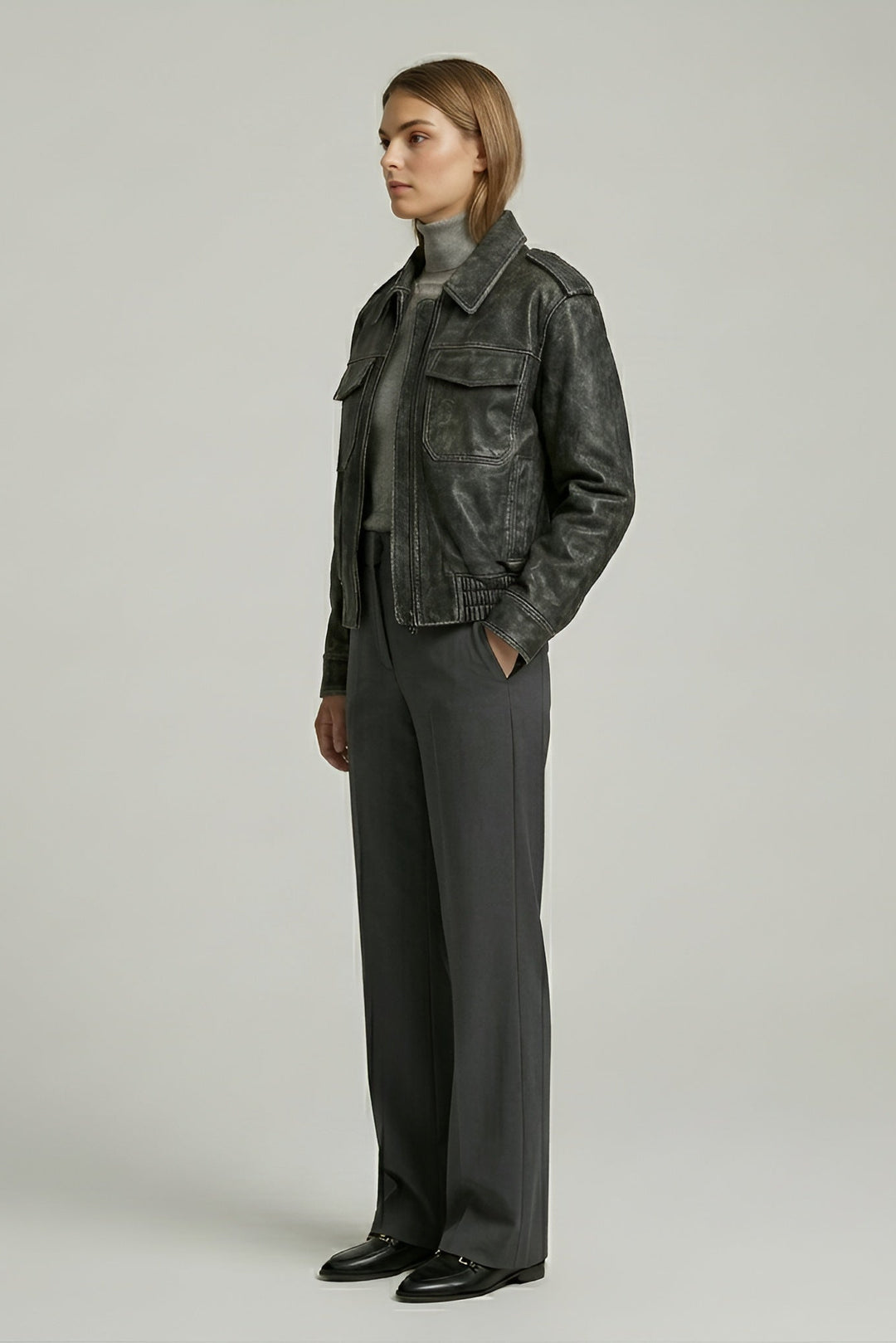 Person wearing a dark gray jacket and pants on a plain background