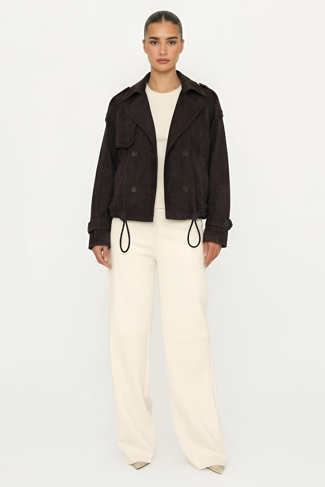 Person wearing a dark jacket and white pants on a light gray background