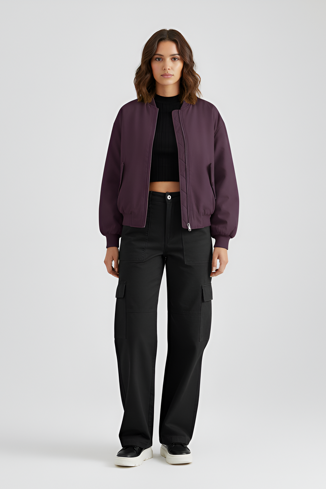 Person wearing a purple jacket and black pants on a light gray background