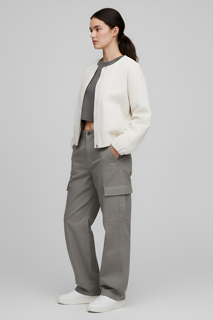 Person wearing a white jacket and gray cargo pants on a plain background