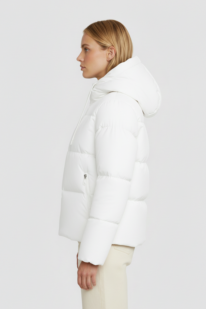 Person wearing a white puffer jacket on a plain background