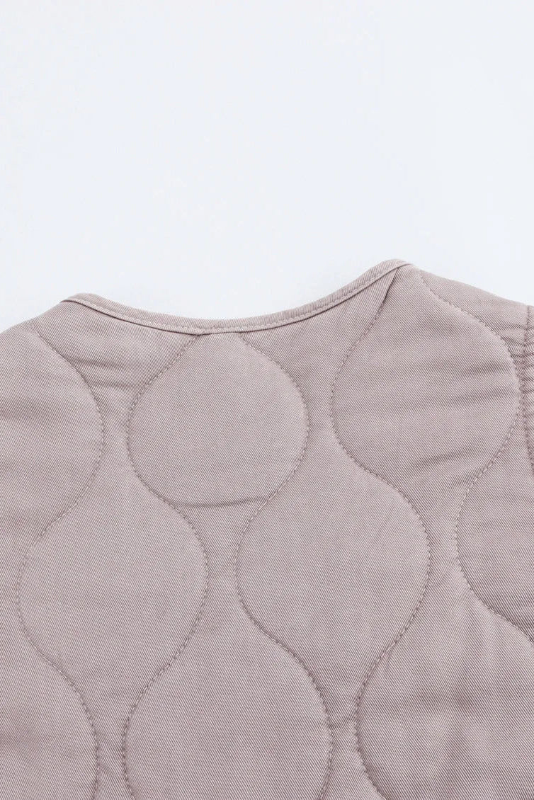 Quilted vest with wavy pattern on a light gray background