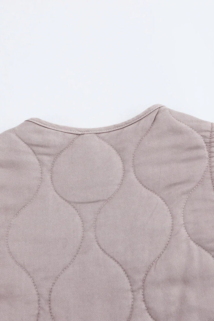 Quilted vest with wavy pattern on a light gray background