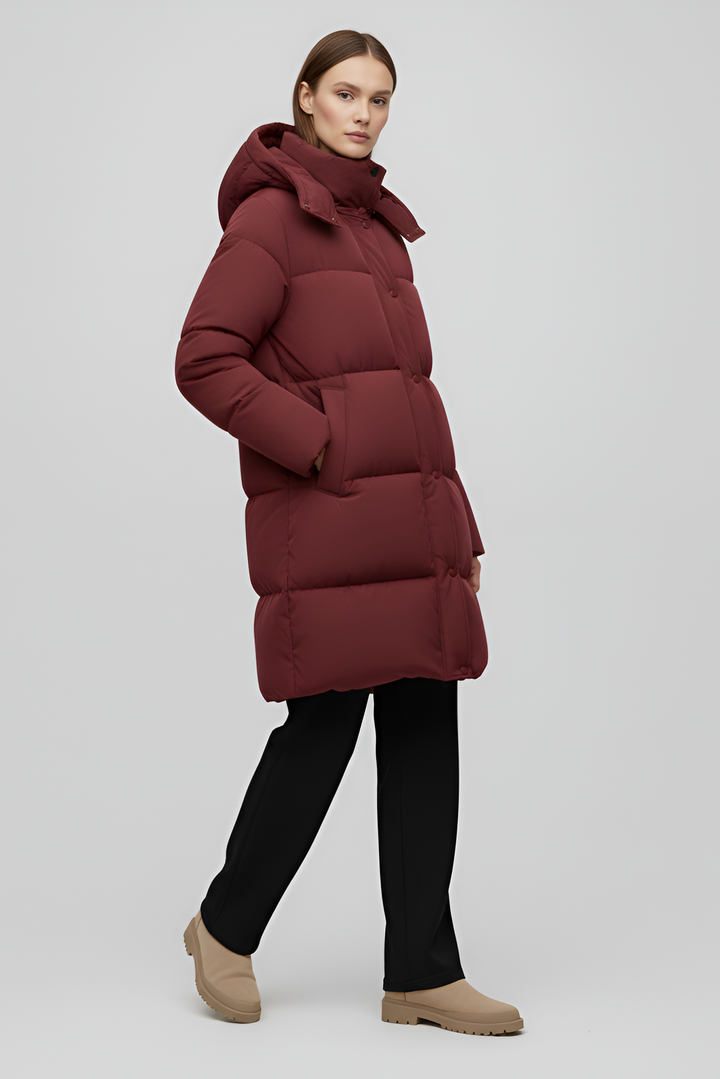 Person wearing a long burgundy puffer coat on a white background