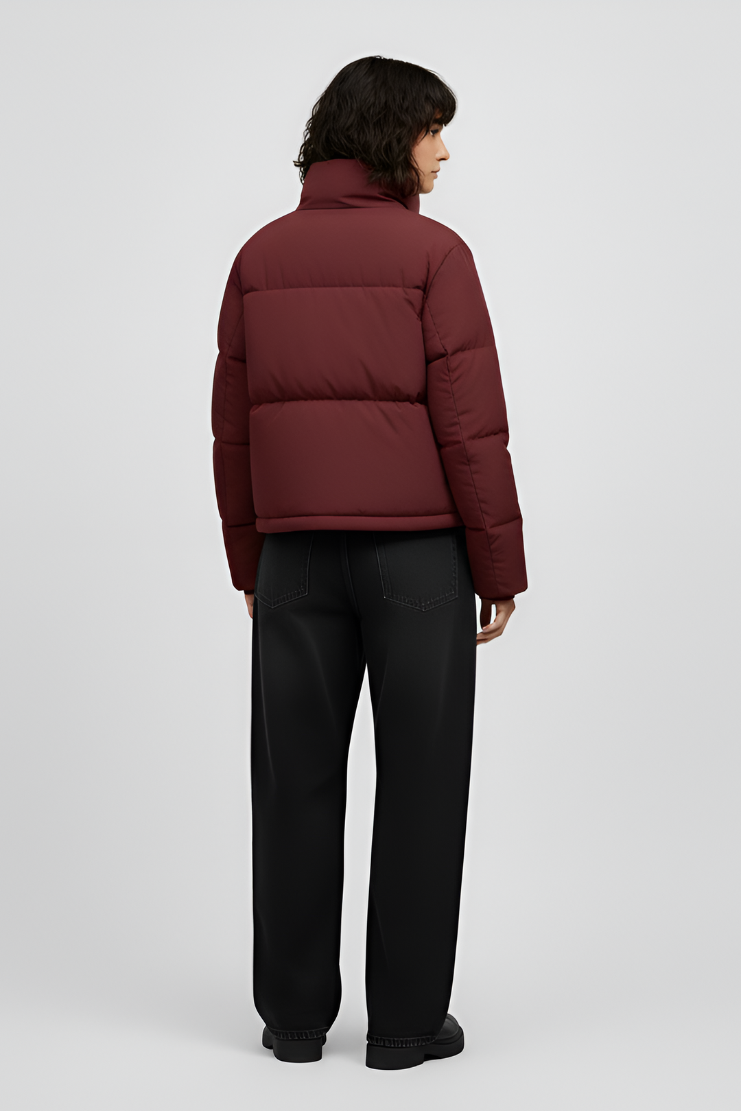 Woman wearing a red jacket and black jeans on a white background