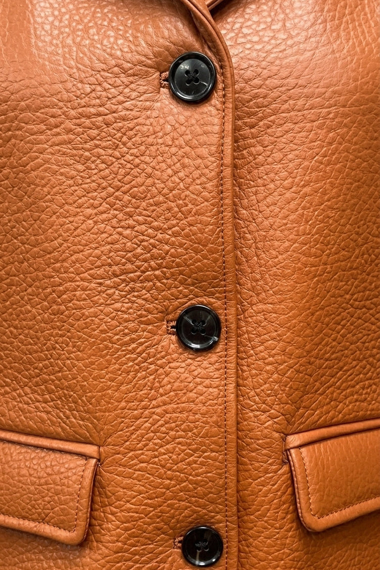 SAWYER - Close-up of tan leather jacket buttons