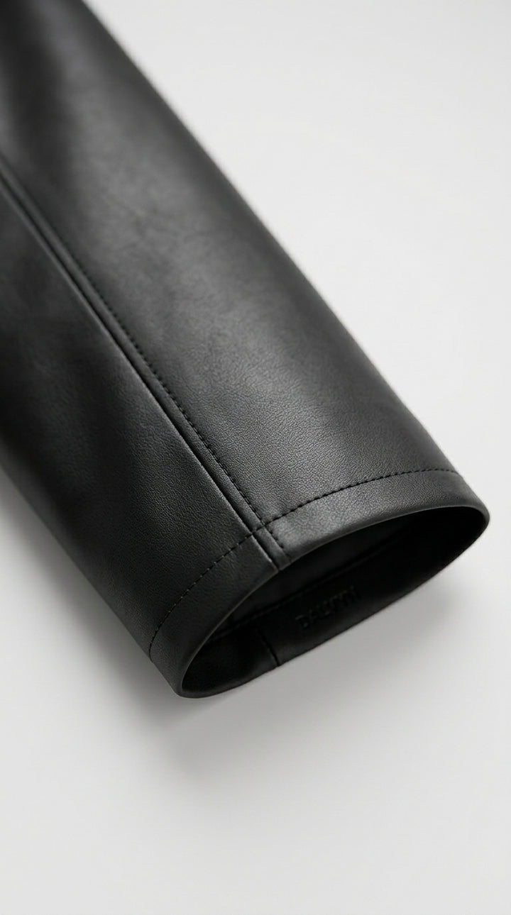 SYLVIANE - Close-up of a black leather jacket sleeve on a light gray background