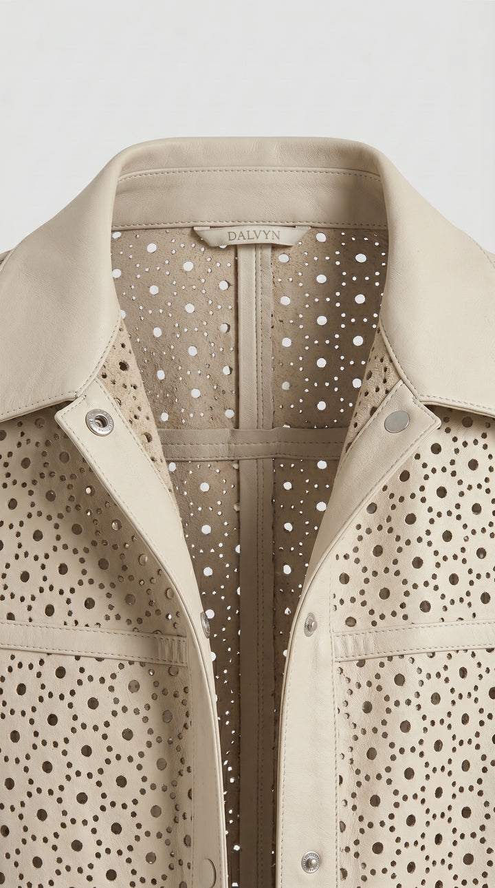 Close-up of a beige leather jacket with a polka dot pattern on a white background