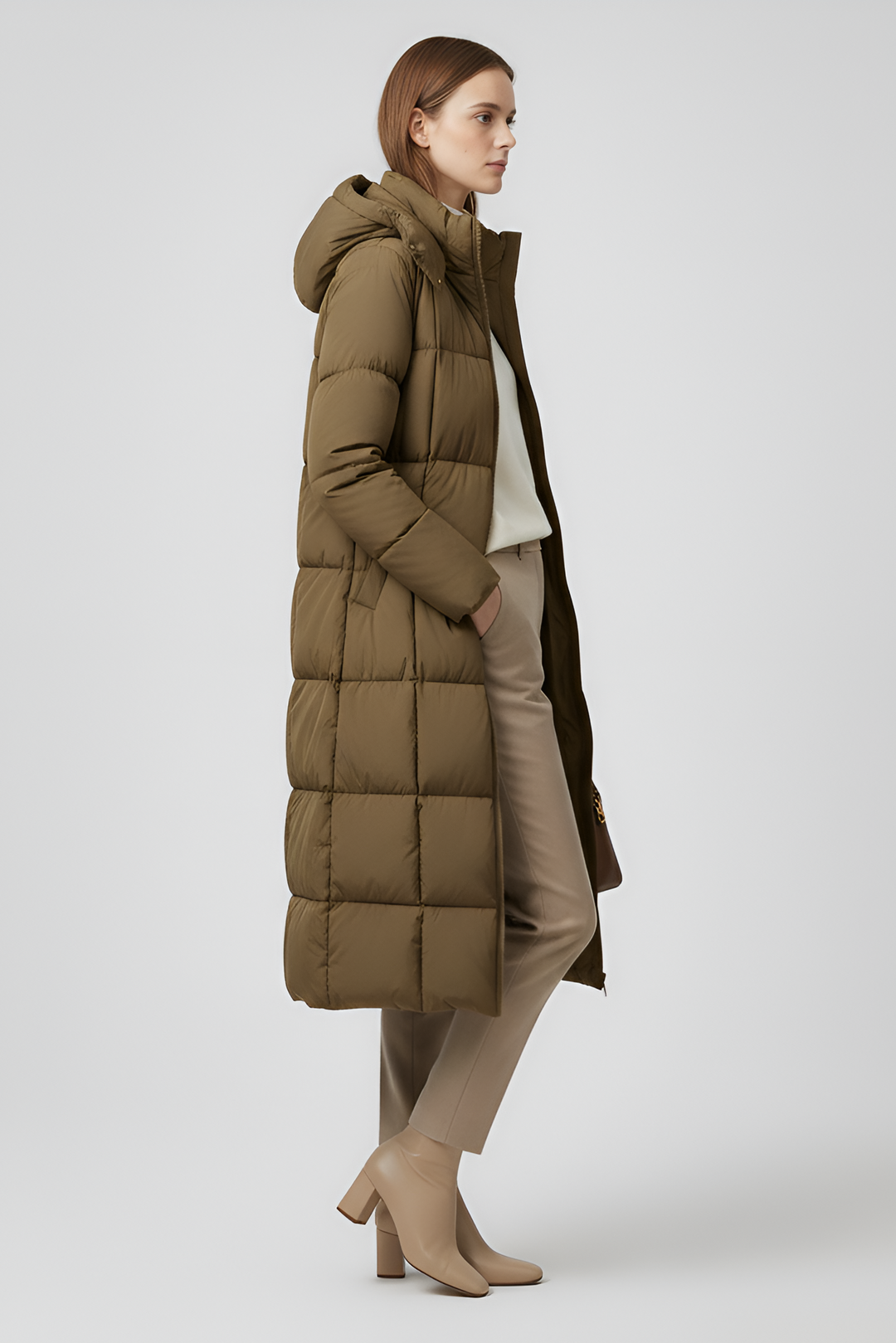 VALERIN Woman wearing a long brown puffer coat on a light gray background