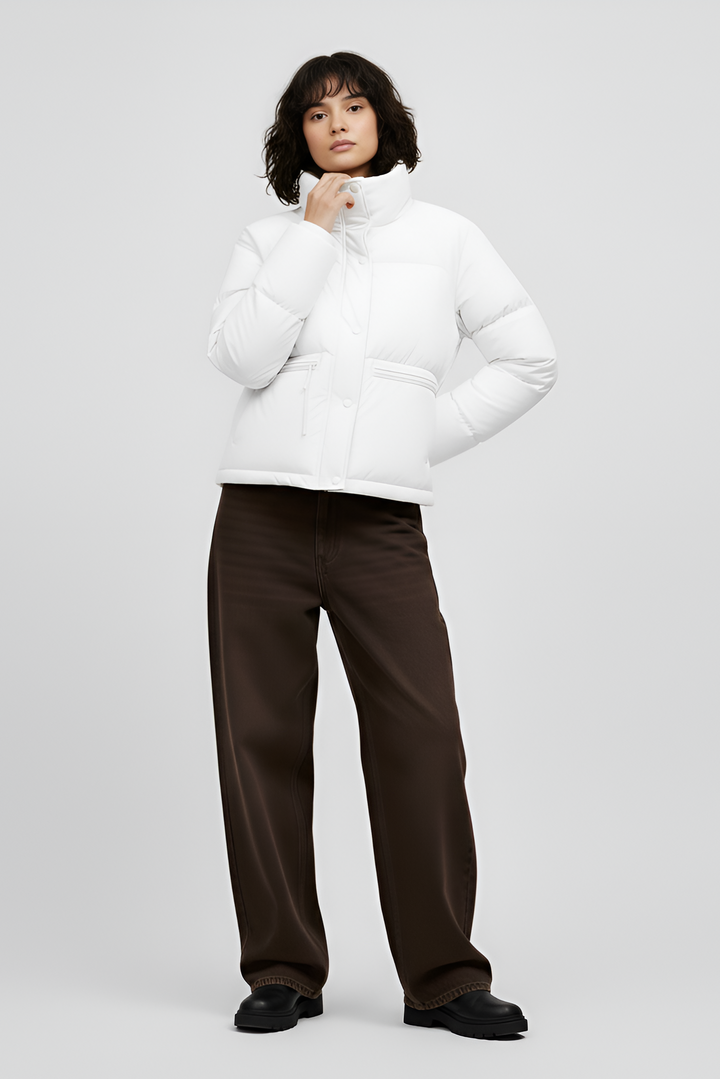 Woman wearing a white puffer jacket and pants on a light gray background