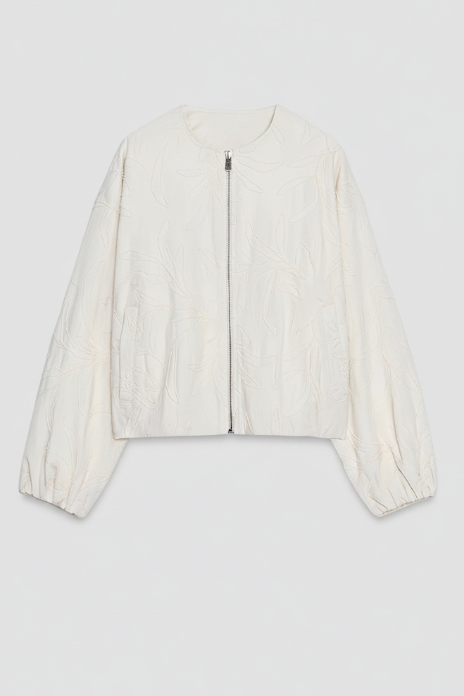 White blouse with sheer sleeves on a light gray background