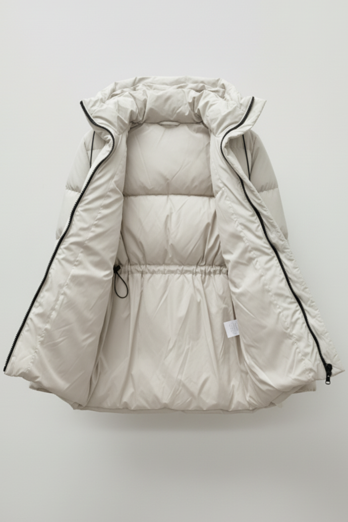 White puffer vest with black trim on a light gray background