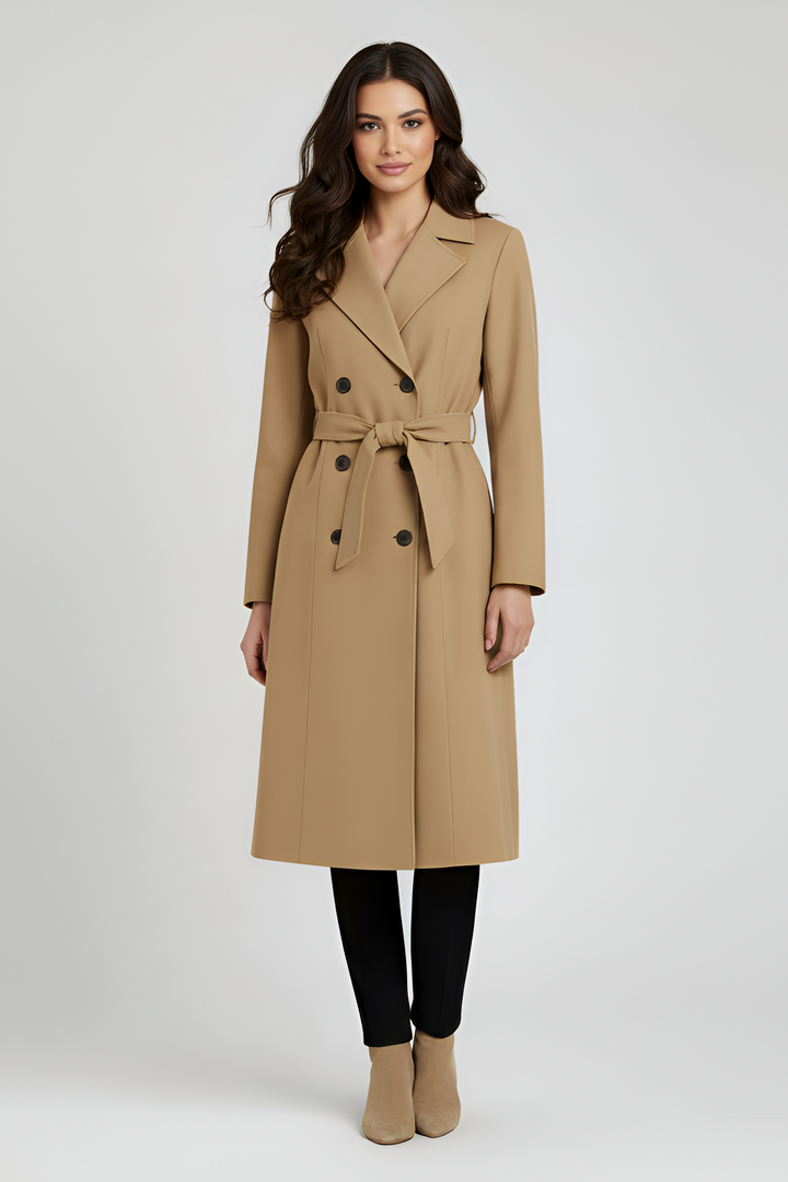 Woman wearing a green coat standing against a white background