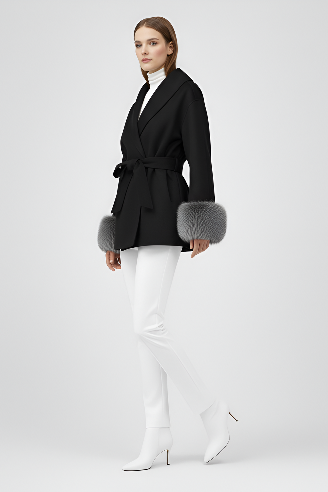 Woman wearing a black coat with fur cuffs on a white background