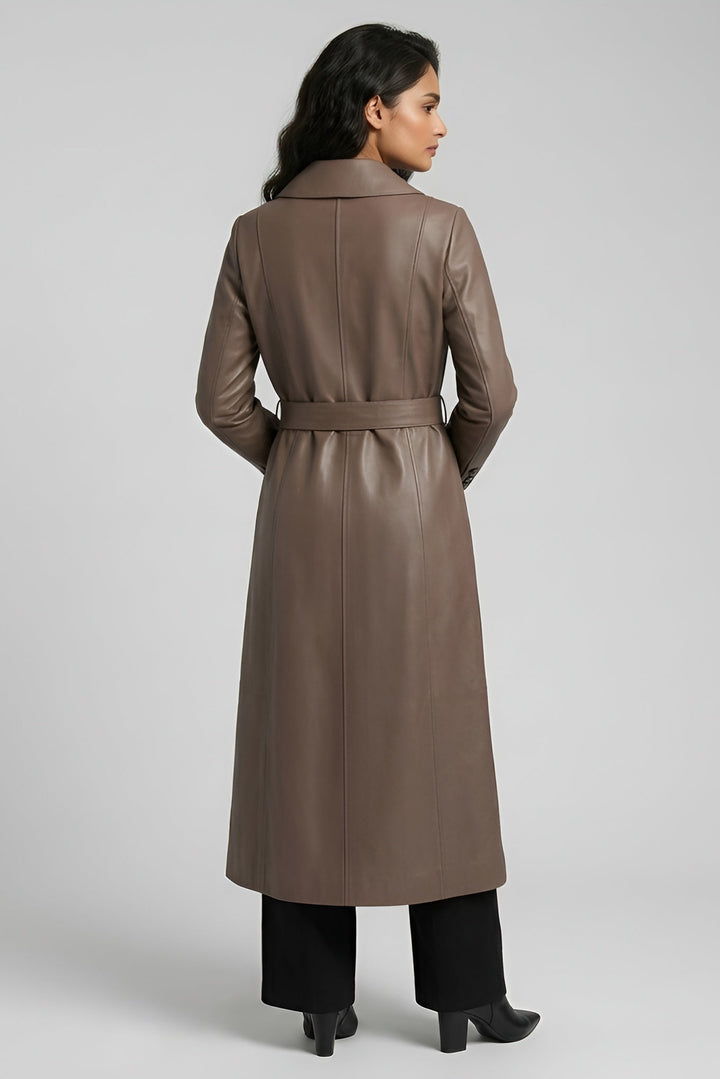 Woman wearing a long brown coat on a gray background