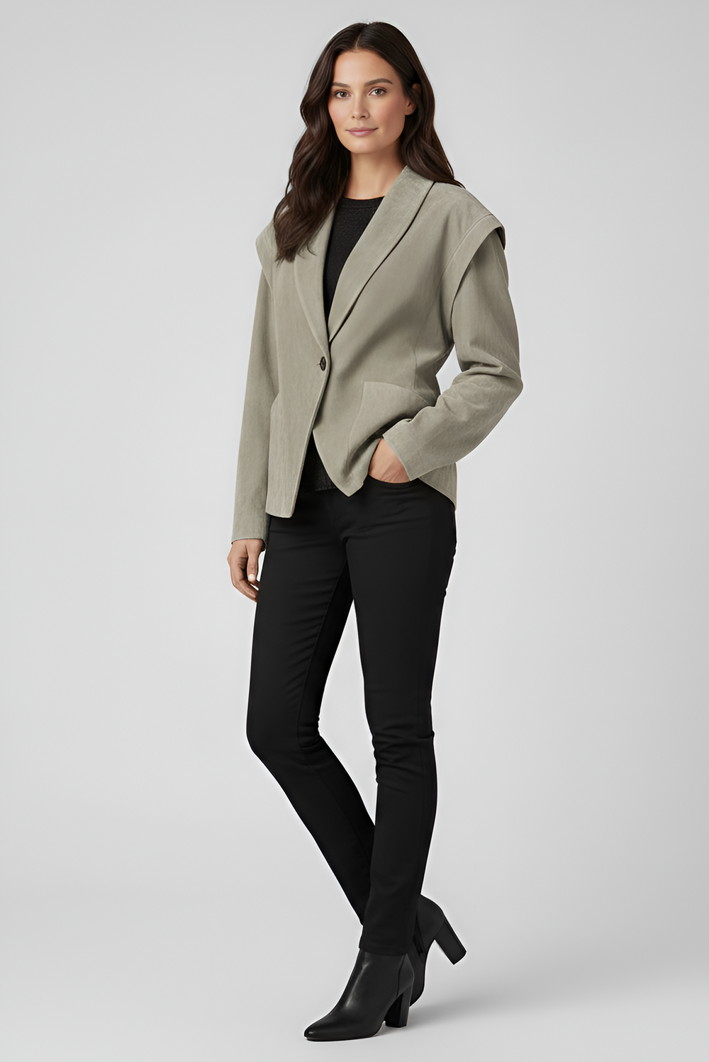 Woman wearing a light gray blazer over a black top and pants on a white background