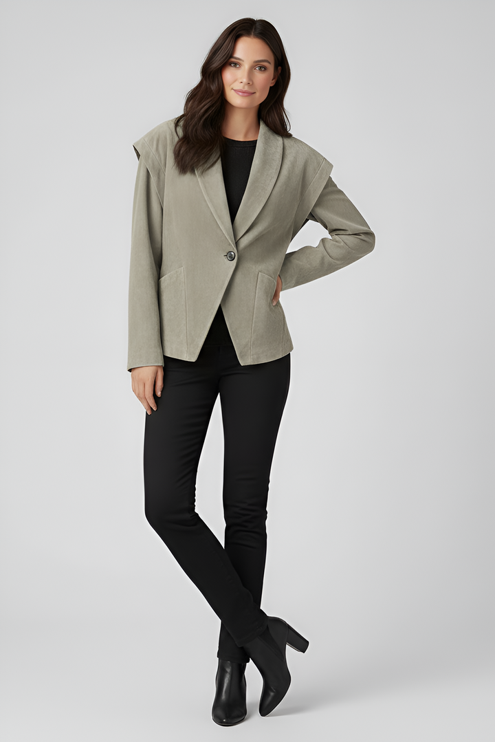 Woman wearing a light gray blazer over a black top and pants on a white background