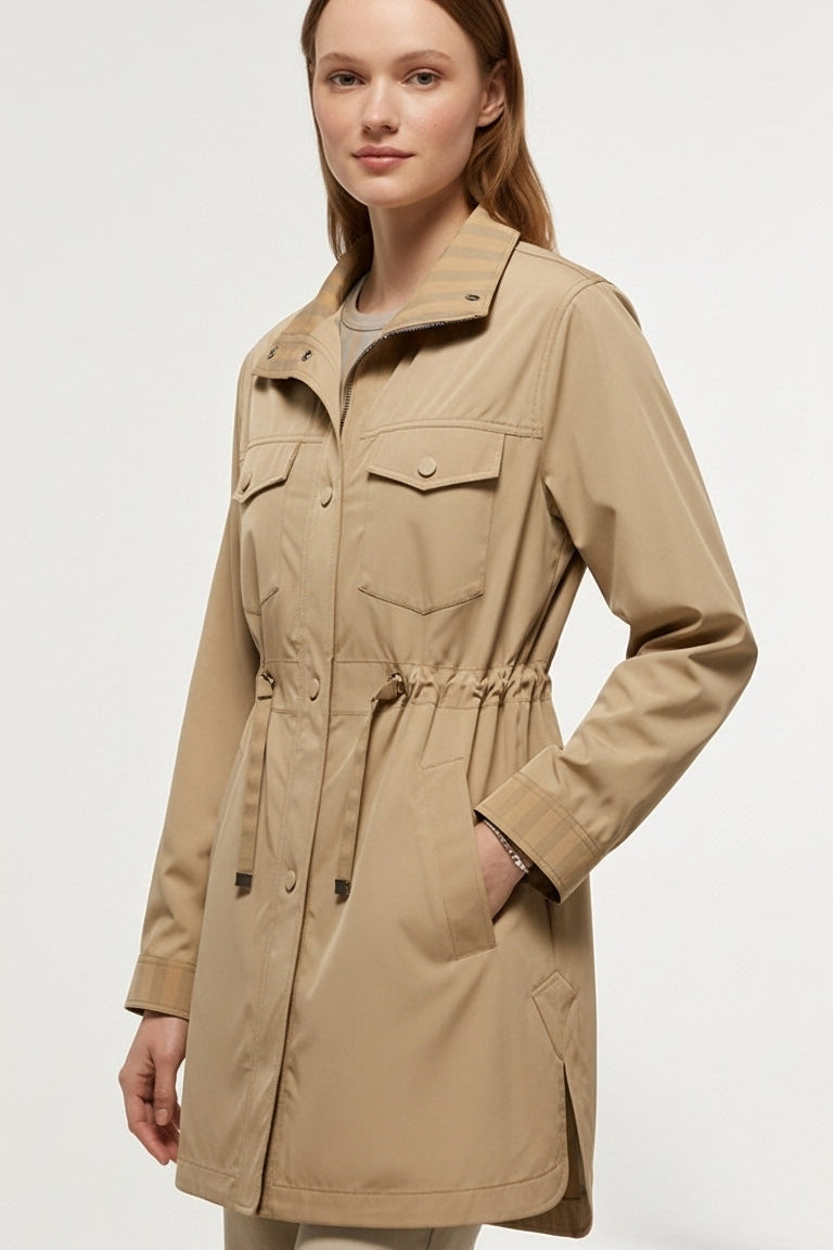 Woman wearing EVELON Spring Trench Coat in soft pink with belt sash and turn-down collar.