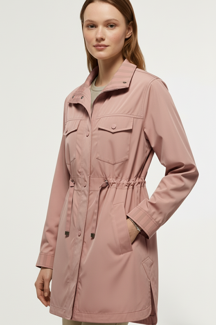 Woman wearing EVELON Spring Trench Coat in soft pink with belt sash and turn-down collar.