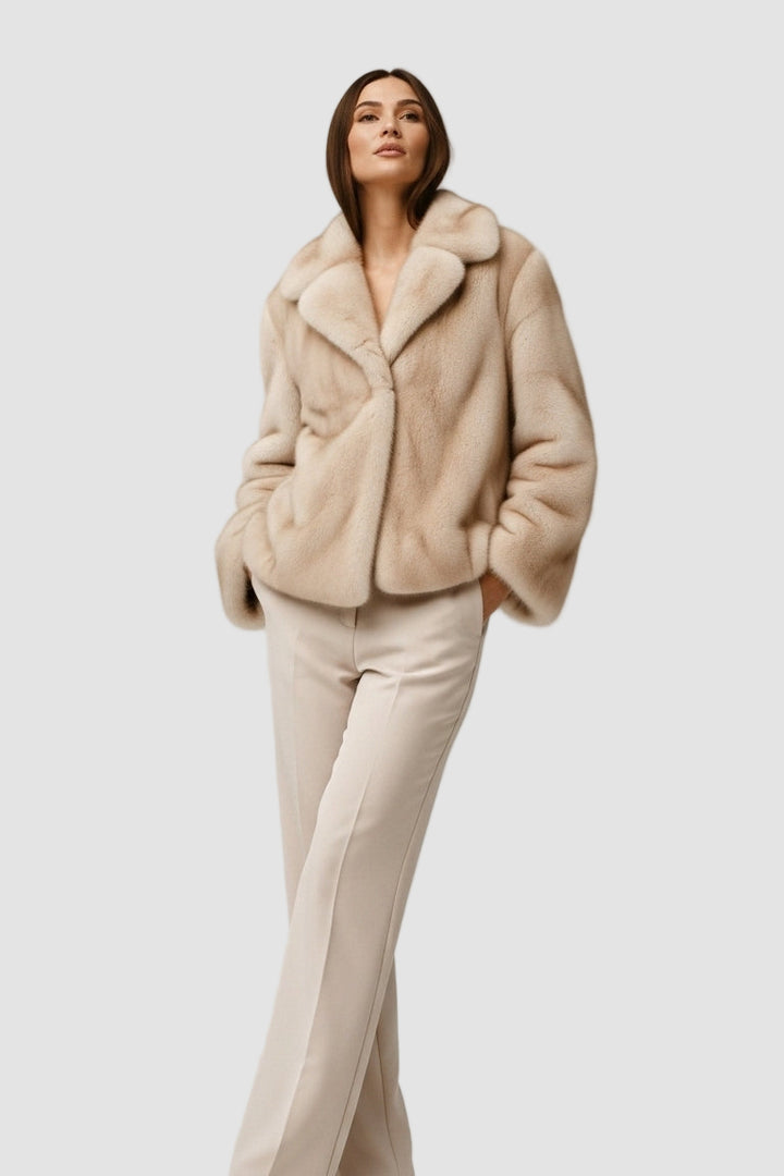 Woman wearing a beige fur coat and pants on a white background
