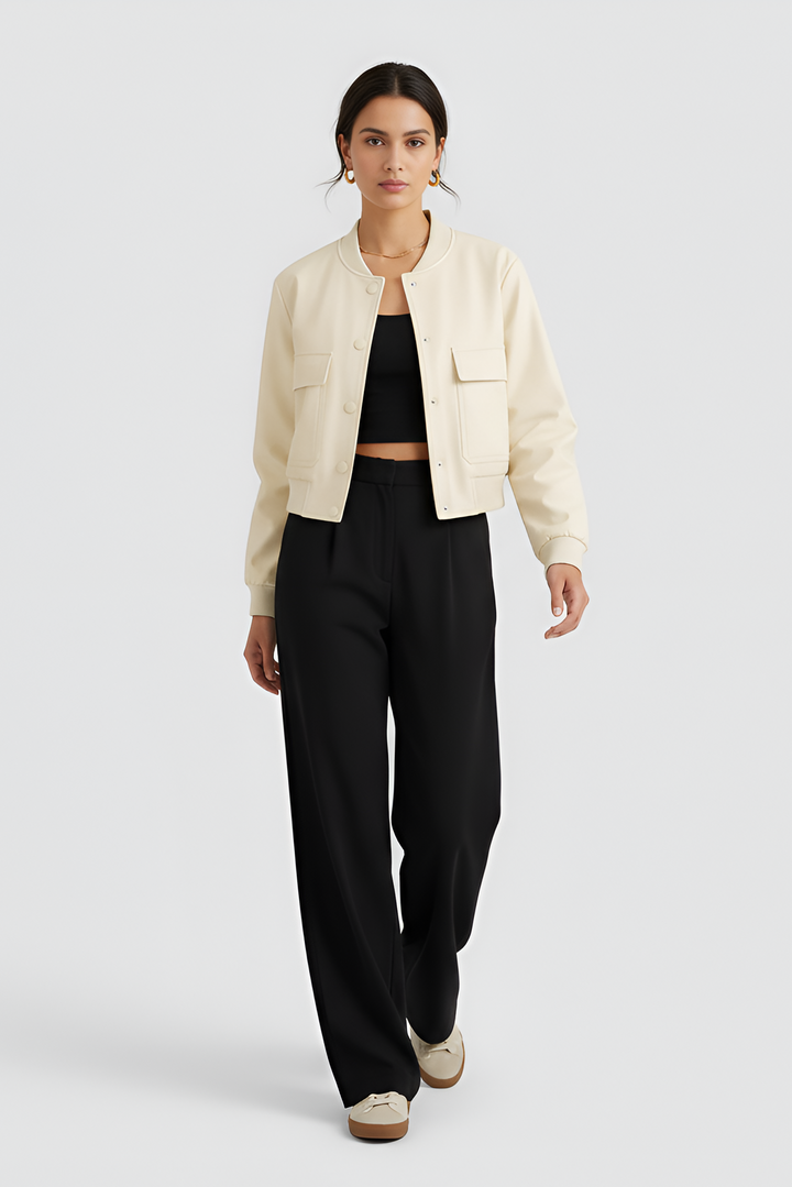 Woman wearing a beige jacket and black pants on a white background