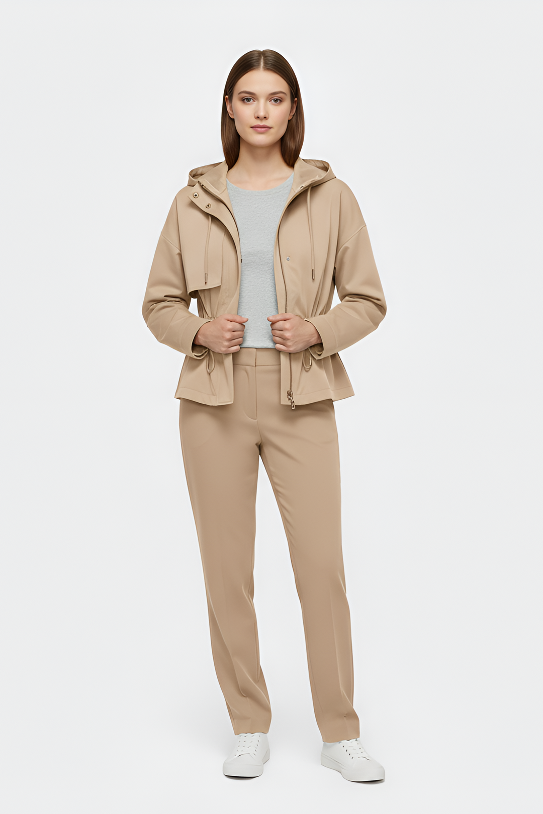 Woman wearing a beige jacket and pants on a white background