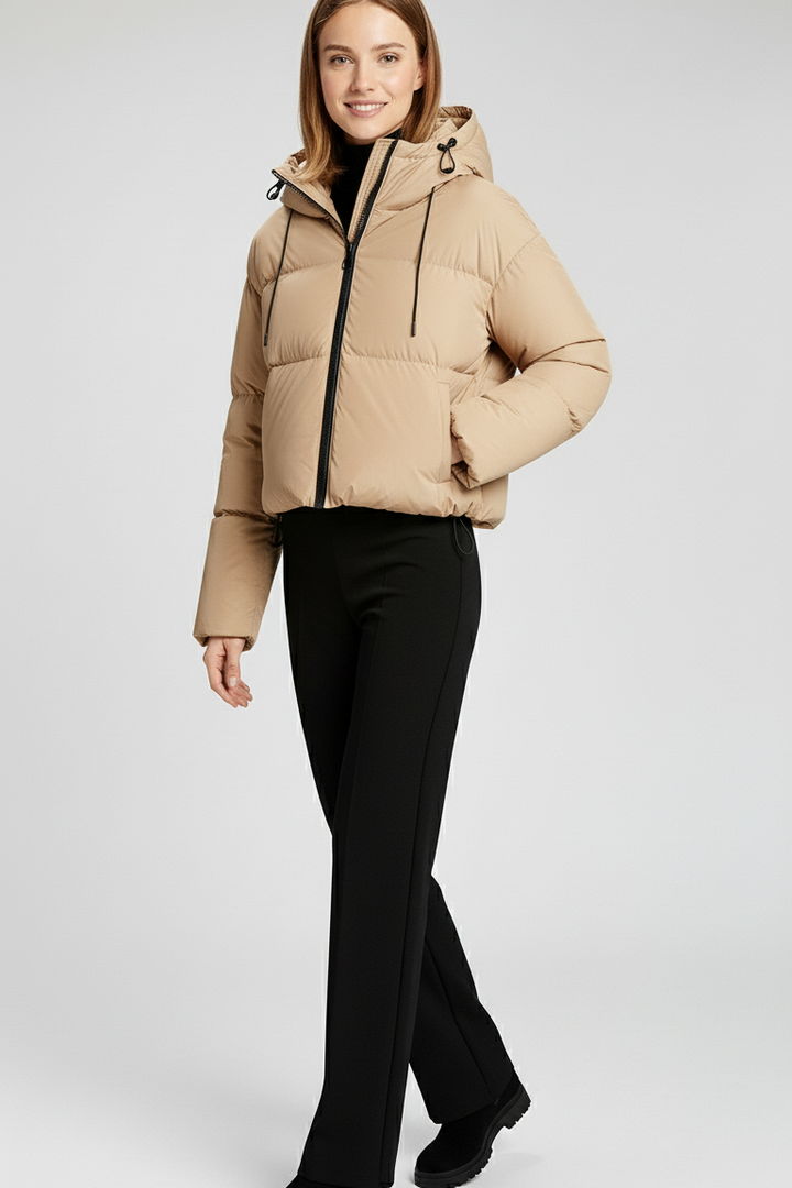 Woman wearing a beige puffer jacket on a white background